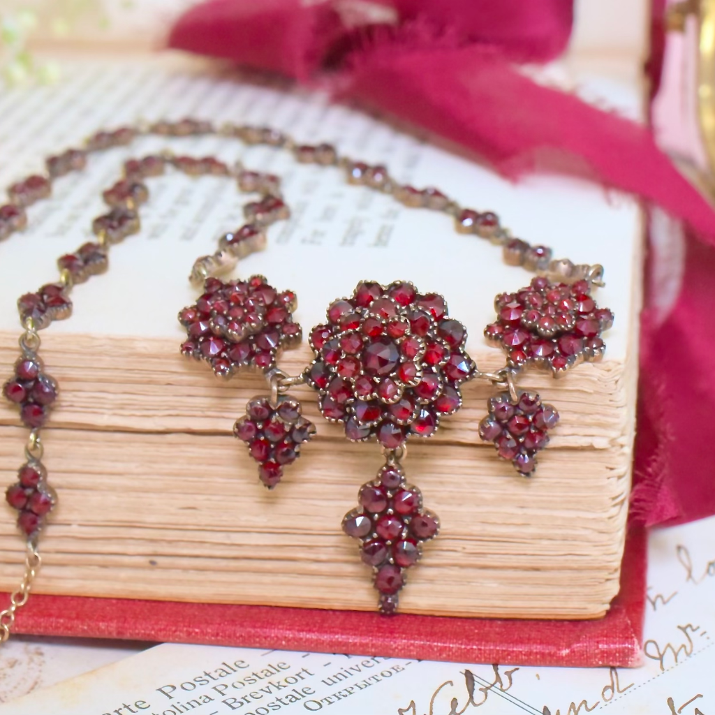 Sold at Auction: A BOHEMIAN GARNET NECKLACE in silver gilt, designed as  five articulated graduated clusters, each set